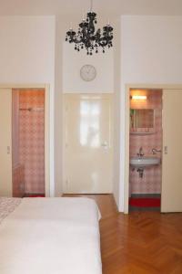 a bedroom with a white bed and a chandelier at Stilhaus-Zimmer im Herzen des Drautales in Feistritz an der Drau