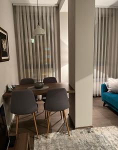 a living room with a dining room table and chairs at Apartmani SOVA in Novi Pazar