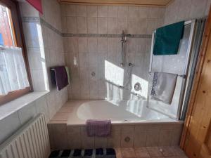 uma casa de banho com banheira e chuveiro em Apartment Hinterkerschbaum - BRG105 by Interhome em Taxenbach