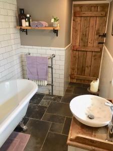 a bathroom with a tub and a toilet and a sink at Garden Cottage in Wetherby