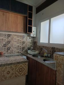 uma cozinha com um lavatório e uma janela em Appart hôtel cozy em Bouzareah