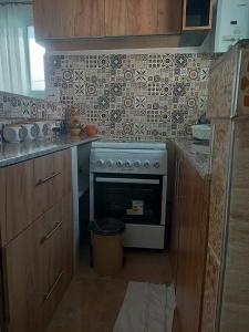 a kitchen with a stove and a counter top at Appart hôtel cozy in Bouzareah