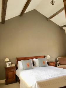 a bedroom with a bed with white sheets and pillows at Garden Cottage in Wetherby