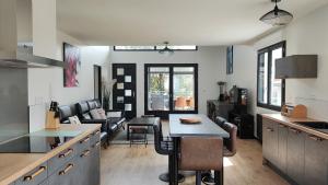 une cuisine avec une table et un salon dans l'établissement Villa Papillon***. Location appartement 1er étage., à Ronce-les-Bains