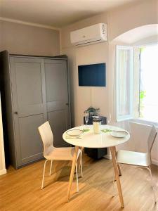 Al Glicine Apartments في لازيسي: غرفة طعام مع طاولة بيضاء وكراسي +62 صورة