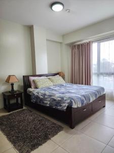 a bedroom with a bed and a window at SERIN WEST TAGAYTAY-Spacious & Comfy 2BR Unit with Parking and Balcony in Tagaytay