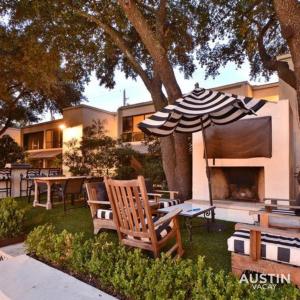 un patio con sombrilla, sillas y parrilla en Amenity Heavy Serene Apt in Convenient Location, en Austin