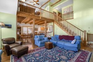 a living room with blue couches and a staircase at Family Tides - 311 - 139th Street home in Ocean City +39 photos