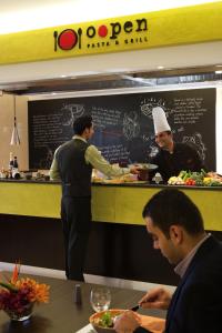 
a man standing at a counter with a plate of food at ibis Amman in Amman
