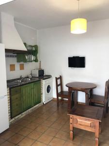 een keuken met een tafel, een wastafel en een fornuis bij Apartamentos Cala Isabel in Zahora