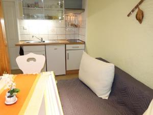 uma pequena cozinha com uma cama e uma almofada branca em Apartment Osterende-2 by Interhome em Süderwisch