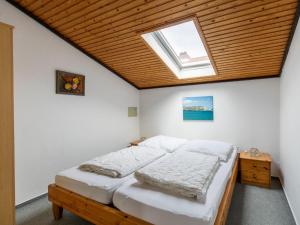 a bedroom with a bed and a skylight at Apartment Nordsee-Ferienhaus-1 by Interhome in Friedrichskoog