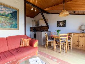 a living room with a red couch and a table at Apartment Nordsee-Ferienhaus-1 by Interhome in Friedrichskoog