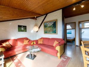 un soggiorno con divano rosso e tavolo di Apartment Nordsee-Ferienhaus-1 by Interhome a Friedrichskoog