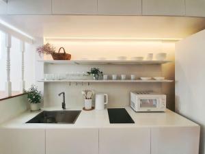 a kitchen with a sink and a microwave at InJoy Snow Hotel in Ban Chuat Plai Mai