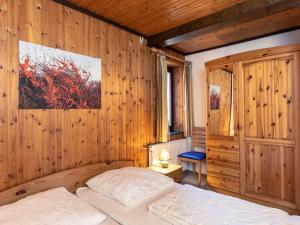a bedroom with a bed and a wooden wall at Apartment Nordsee-Ferienhaus-2 by Interhome in Friedrichskoog