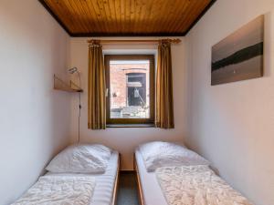 two beds in a room with a window at Apartment Nordsee-Ferienhaus-2 by Interhome in Friedrichskoog