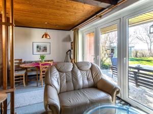 - un salon avec un canapé en cuir et une table dans l'établissement Apartment Nordsee-Ferienhaus-2 by Interhome, à Friedrichskoog