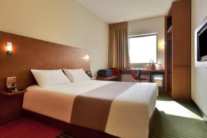 um quarto de hotel com uma cama grande e uma janela em ibis Amman em Amã
