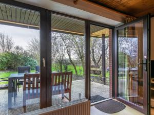 Elle offre une vue intérieure sur une véranda dotée de portes coulissantes en verre. dans l'établissement Apartment Nordsee-Ferienhaus-5 by Interhome, à Friedrichskoog