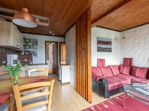 een woonkamer met een rode bank en een tafel bij Apartment Nordsee-Ferienhaus-5 by Interhome in Friedrichskoog