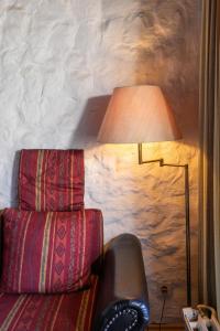 une lampe assise à côté d'une chaise près d'un mur dans l'établissement Apartment Nordsee-Ferienhaus-5 by Interhome, à Friedrichskoog