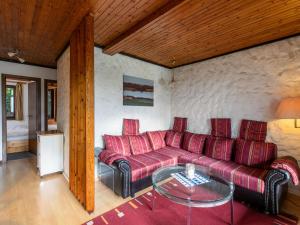 - un salon avec un canapé rouge et une table en verre dans l'établissement Apartment Nordsee-Ferienhaus-5 by Interhome, à Friedrichskoog