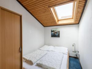 a small bedroom with a bed with a skylight at Apartment Nordsee-Ferienhaus-4 by Interhome in Friedrichskoog