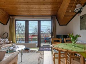 a living room with a wooden ceiling and a table at Apartment Nordsee-Ferienhaus-4 by Interhome in Friedrichskoog +24 photos
