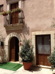 a building with a balcony and a door and plants at Affittacamere Resalibera in Siracusa