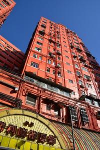 wysoki budynek z czerwonej cegły z zegarem przed nim w obiekcie The Cultural Crashpad - 康乃馨旅館 w Hongkongu