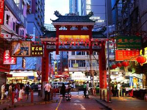 una strada cittadina con una struttura cinese al centro di The Cultural Crashpad - 康乃馨旅館 a Hong Kong