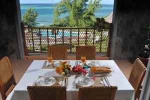 a table with food and a view of the ocean at La Belle Rodriguaise in Rodrigues Island