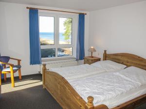 ein Schlafzimmer mit einem Bett und einem großen Fenster in der Unterkunft Apartment Blaumuschel - LUB108 by Interhome in Lubmin