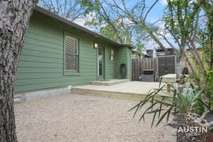 ein grünes Haus mit einer Terrasse davor in der Unterkunft Walk to Lady Bird Lake from Perfectly Quaint Home in Austin