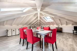 una sala da pranzo con tavolo e sedie rosse di [500 mt. DAL MARE] WiFi Clima & Design a Porto San Giorgio