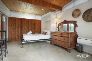 a bedroom with a bed and a dresser and a mirror at Entertaining Charmer w Outdoor Games and Putt-Putt in Austin