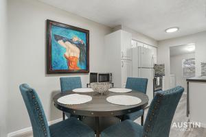 a dining room with a table and chairs and a painting at Everything You Need Near S Lamar Perfect Condo in Austin