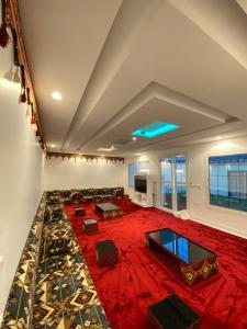 un ampio soggiorno con un grande tappeto rosso di شاليهات غزال للفلل الفندقية الفاخرة a Taif