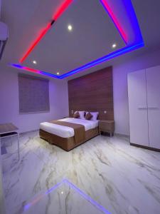 1 dormitorio con 1 cama grande con iluminación roja en شاليهات غزال للفلل الفندقية الفاخرة, en Taif