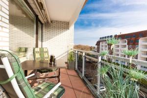 einen Balkon mit einem Tisch, Stühlen und Pflanzen in der Unterkunft Strandnixe 301 in Döse