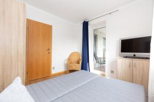 ein Schlafzimmer mit einem Bett und einem Flachbildfernseher in der Unterkunft Strandnixe 301 in Döse