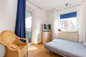 ein Schlafzimmer mit einem Bett, einem Fernseher und einem Fenster in der Unterkunft Strandnixe 301 in Döse