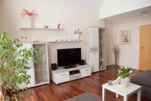 ein Wohnzimmer mit einem TV und weißen Schränken in der Unterkunft Ferienwohnung Am Korretsberg in Kruft
