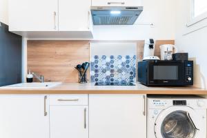 a kitchen with a microwave and a washing machine on a counter at SPACIEUX - Proche-gare - Parking in Bourg-en-Bresse