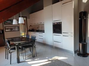 uma cozinha com uma mesa preta e armários brancos em Il piccolo principe em Turim