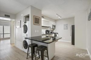 una cucina con bancone e sgabelli in una stanza di Dreamy Outdoor Space New Design in Renovated Apt ad Austin
