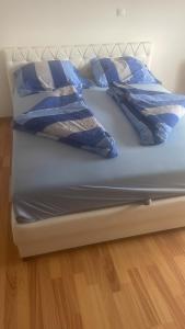 een bed met blauwe lakens en kussens erop bij Sobe Dana in Teslić