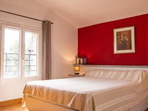 トゥレットにあるHoliday Home La Foux - TUR120 by Interhomeの赤い壁のベッドルーム1室、ベッド1台が備わります。