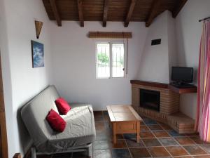 sala de estar con sofá y chimenea en Apartamentos Cala Isabel, en Zahora